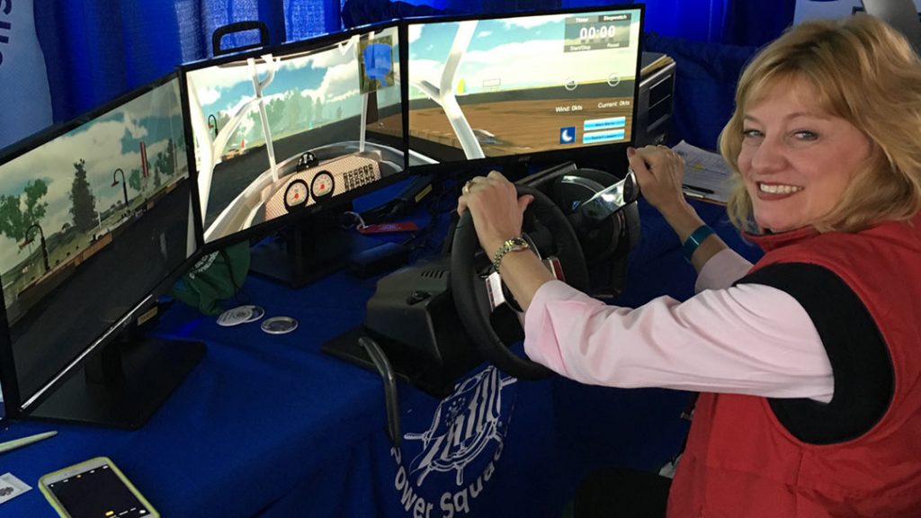 Boating Skills Virtual Trainer with student at the wheel in front of computer screens